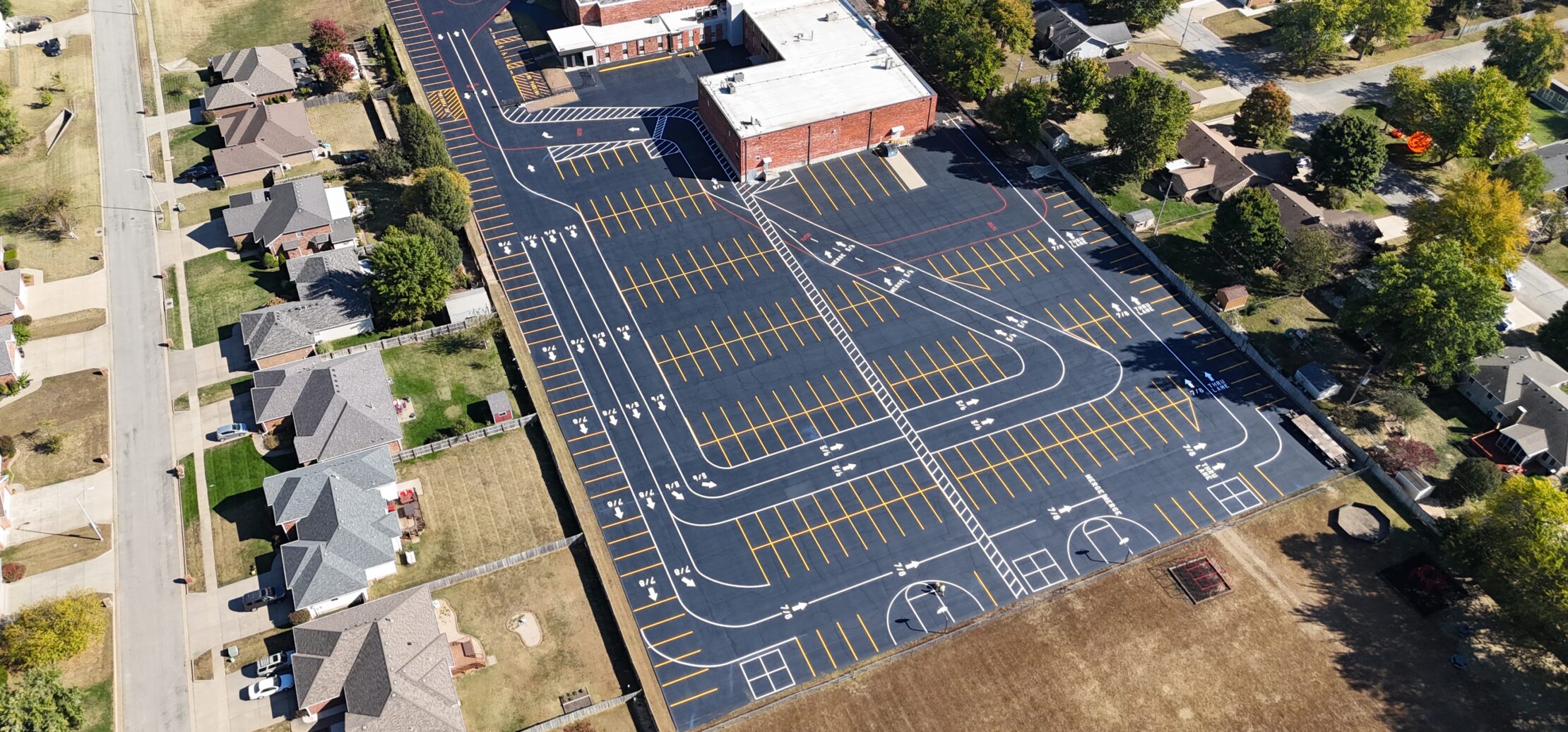 Aerial view of large school lot, courts, and field.