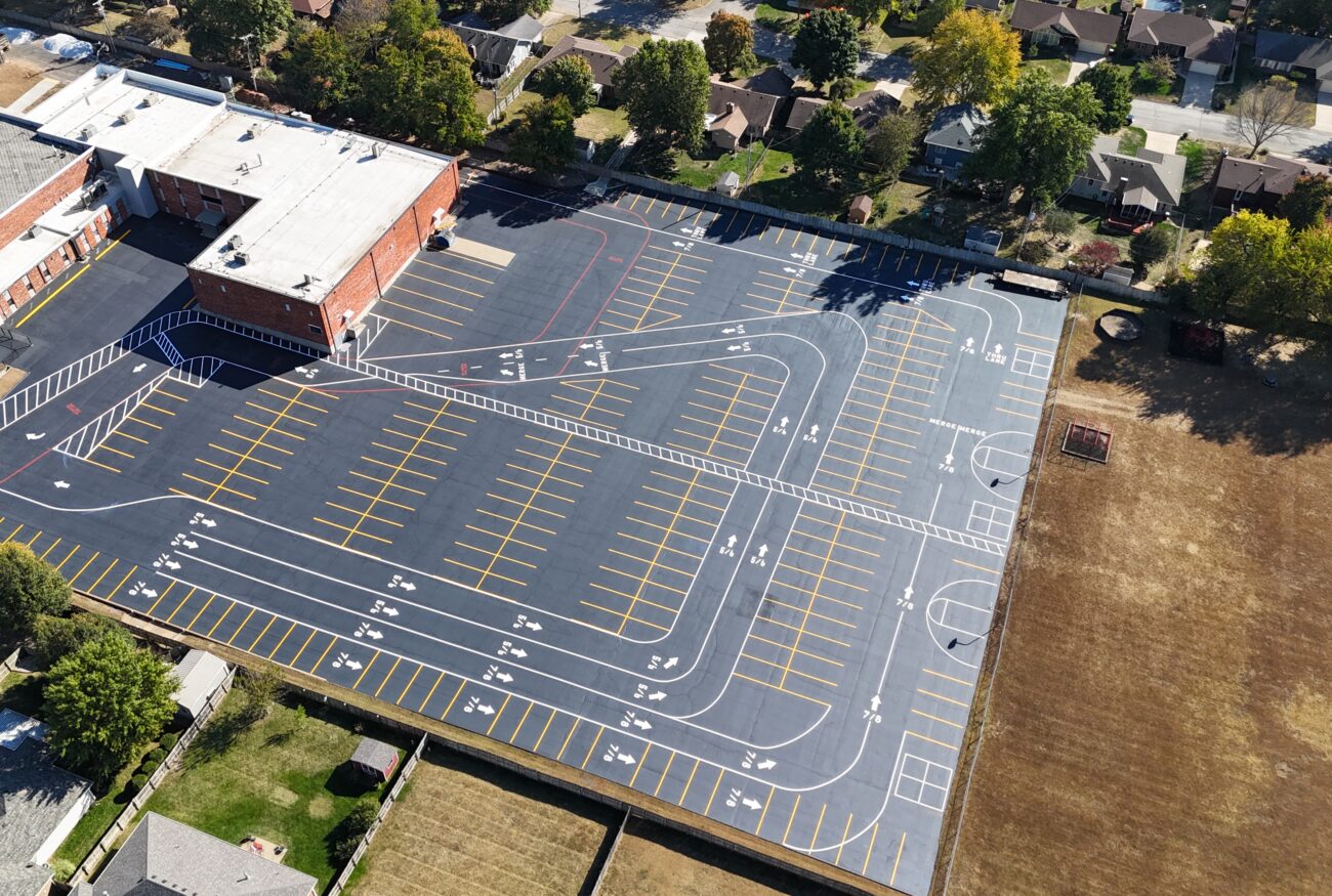 Aerial view of large school lot, courts, and field.