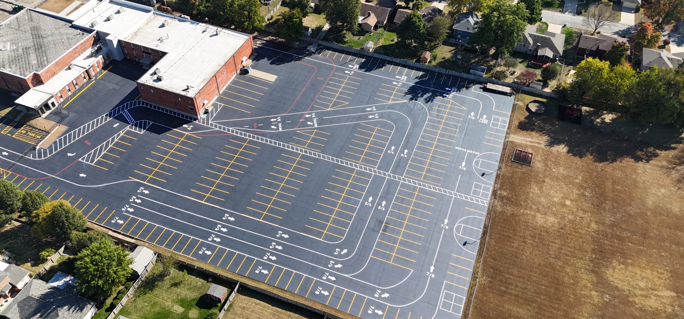 Aerial view of large school lot, courts, and field.