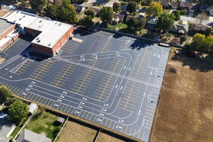 Aerial view of large school lot, courts, and field.
