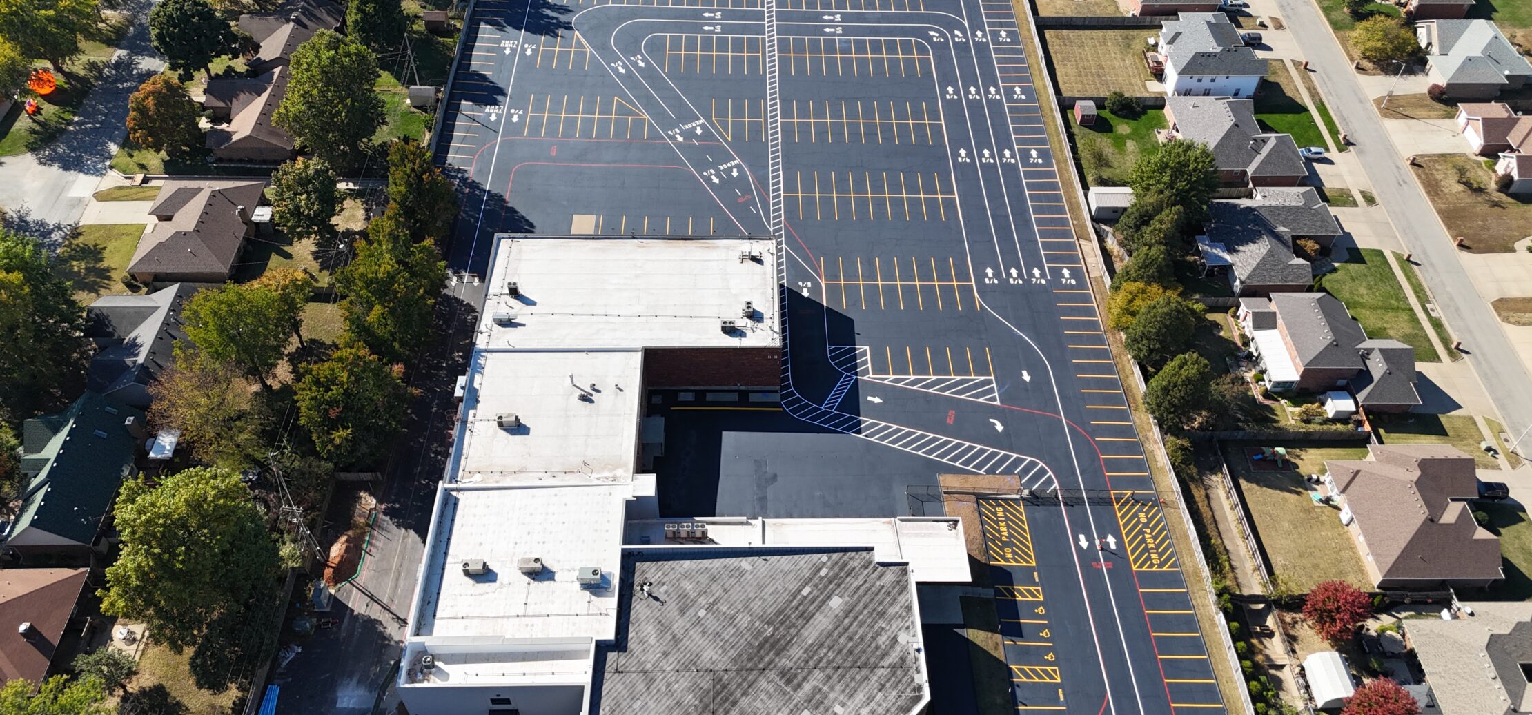 Aerial view of large school lot, courts, and field.