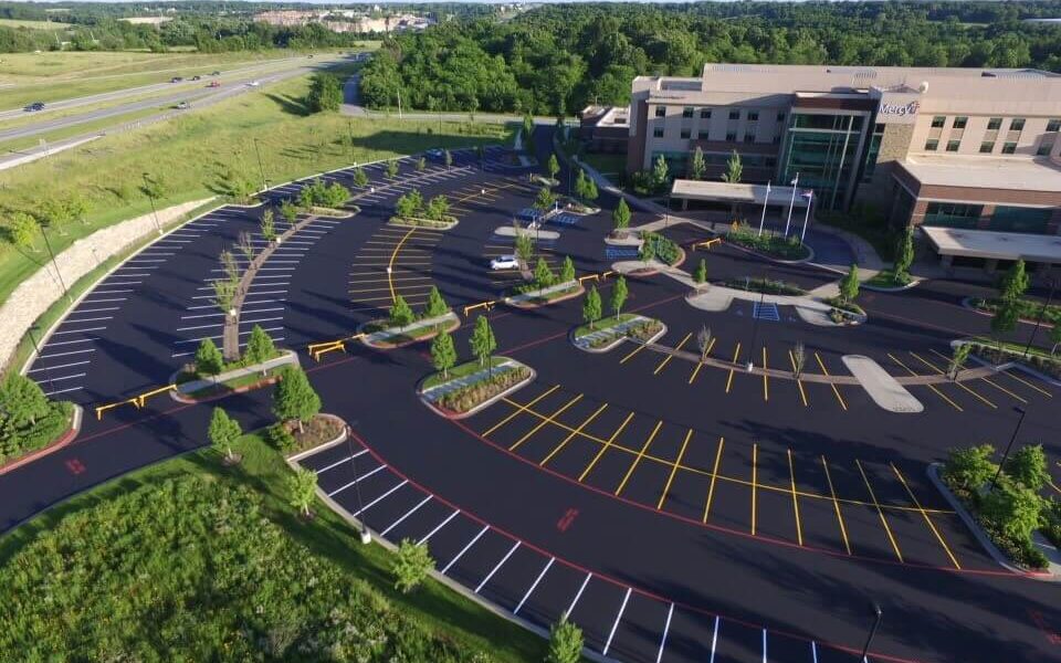 A freshly striped parking lot in front of a hospital.