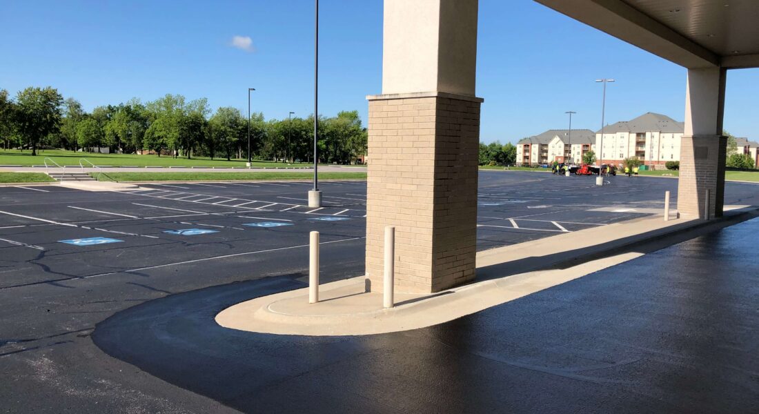 The enterence and parking lot of a building.