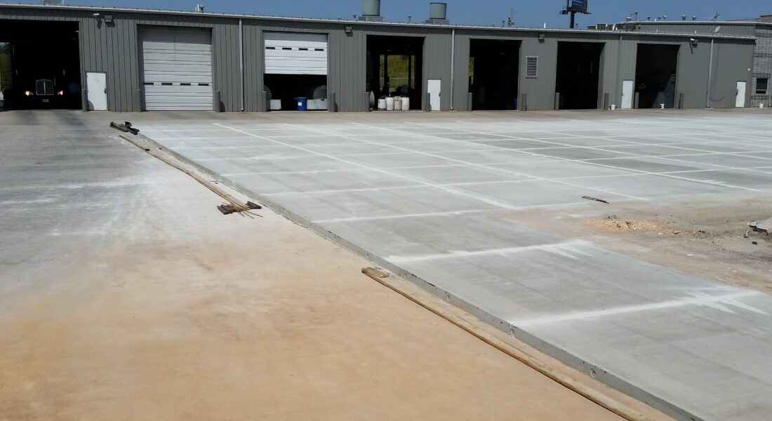 New concrete slabs in front of a workshop.