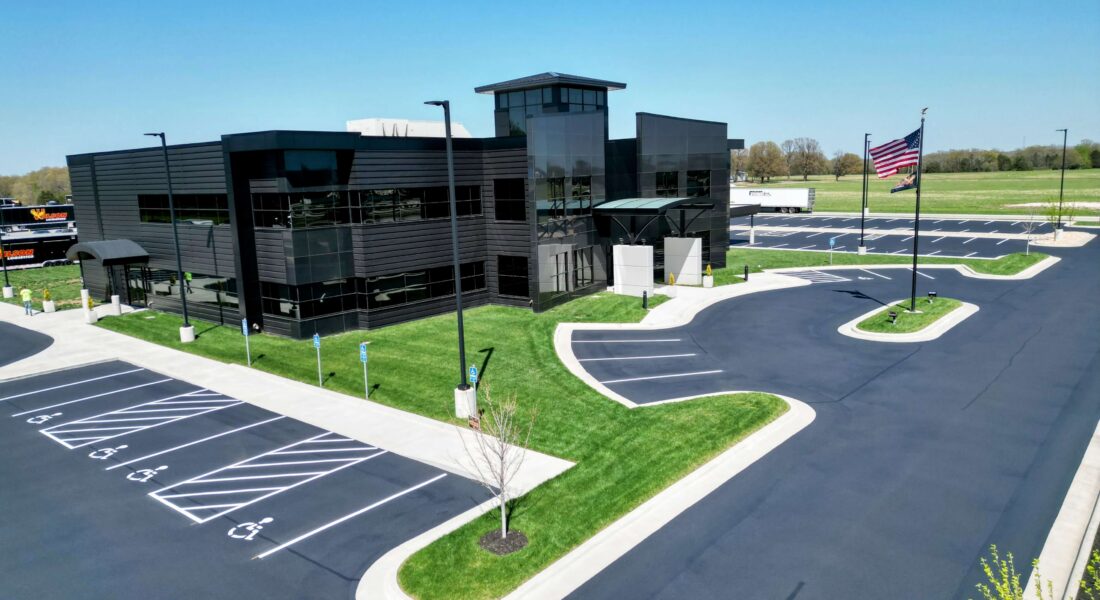 Front of a modern building with a newly painted parking spot lines in the parking lot.