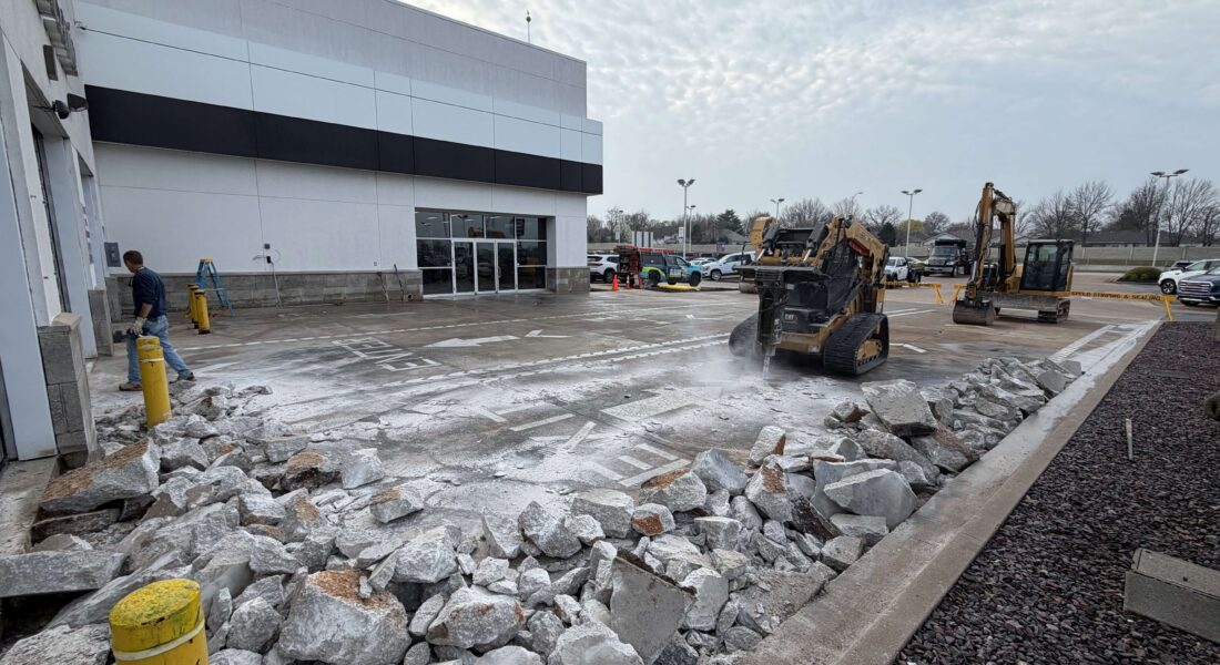 Springfield Striping and Sealing equipment demolishing a parking lot for excavation.